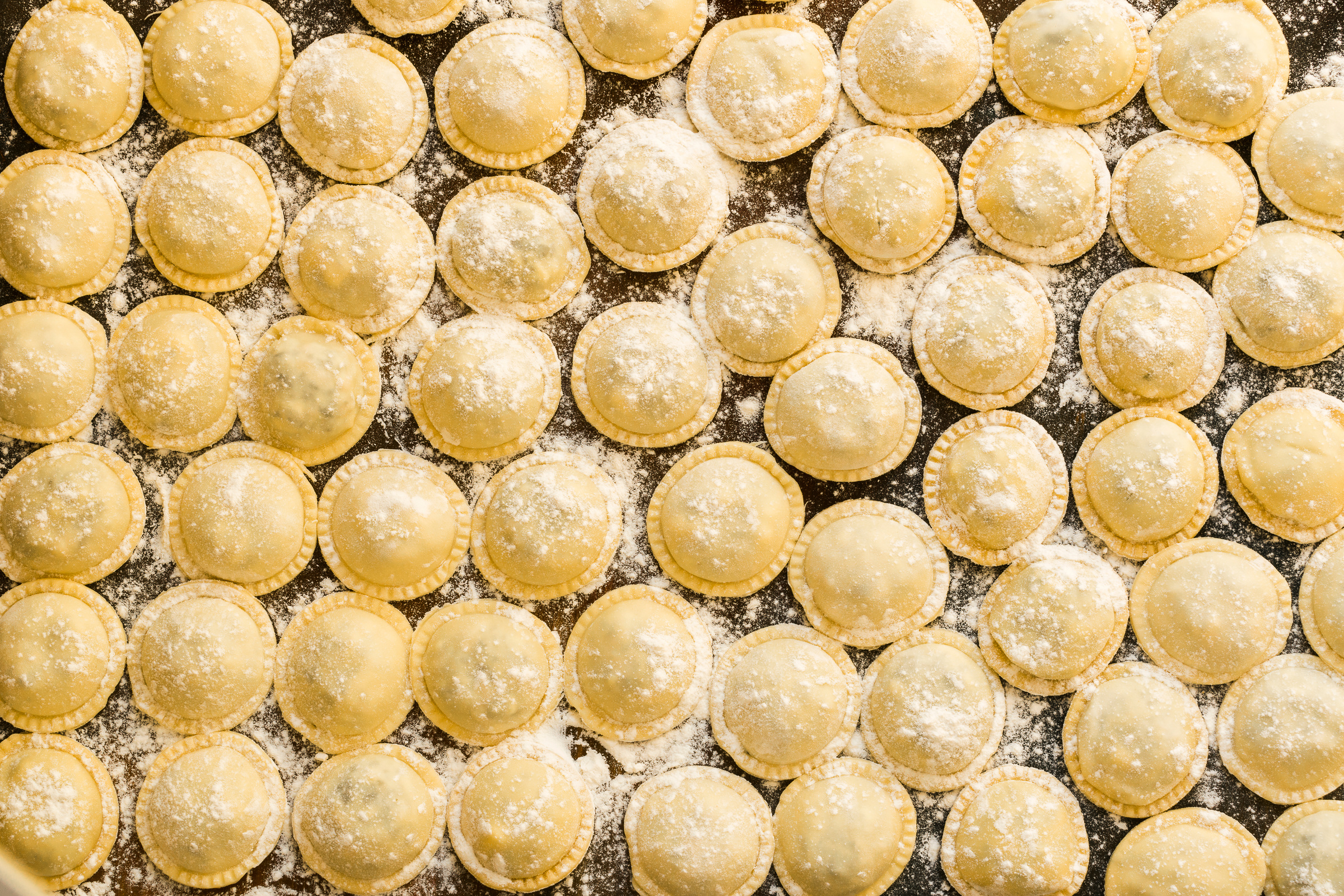 Flat lay with large round raw ravioli (Sorrentino)